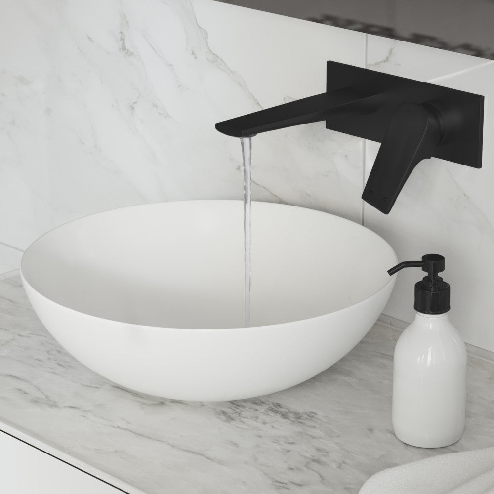 Wall-mount bathroom faucet in matte black, single-handle design, sleek angular spout with flowing water.