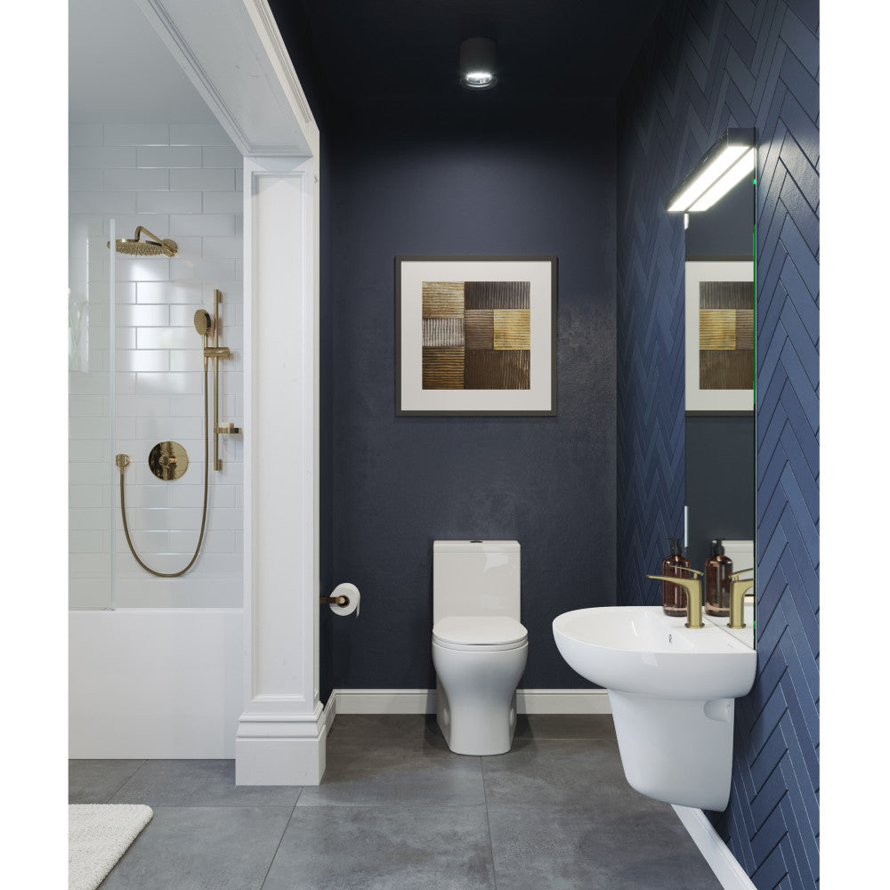 White wall-mount bathroom sink with rounded basin and chrome faucet on dark blue tiled wall.