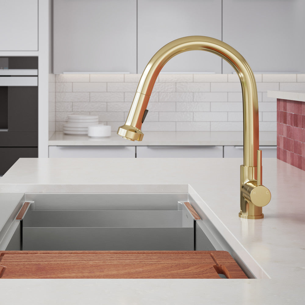 Single-handle pull-down kitchen faucet in brushed gold with curved spout and spray head.