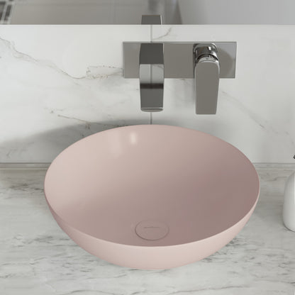 Matte pink ceramic vessel sink with round bowl and smooth matte finish on marble countertop.