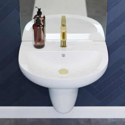 White ceramic wall-mount sink with gold faucet and amber soap dispenser on navy tile background.