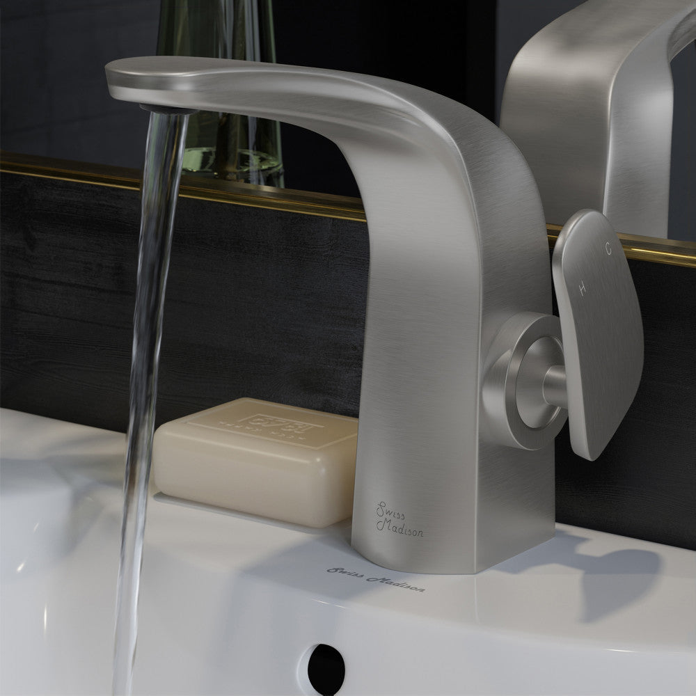 Single-handle bathroom faucet in brushed nickel with curved spout, water flowing, installed on white sink.