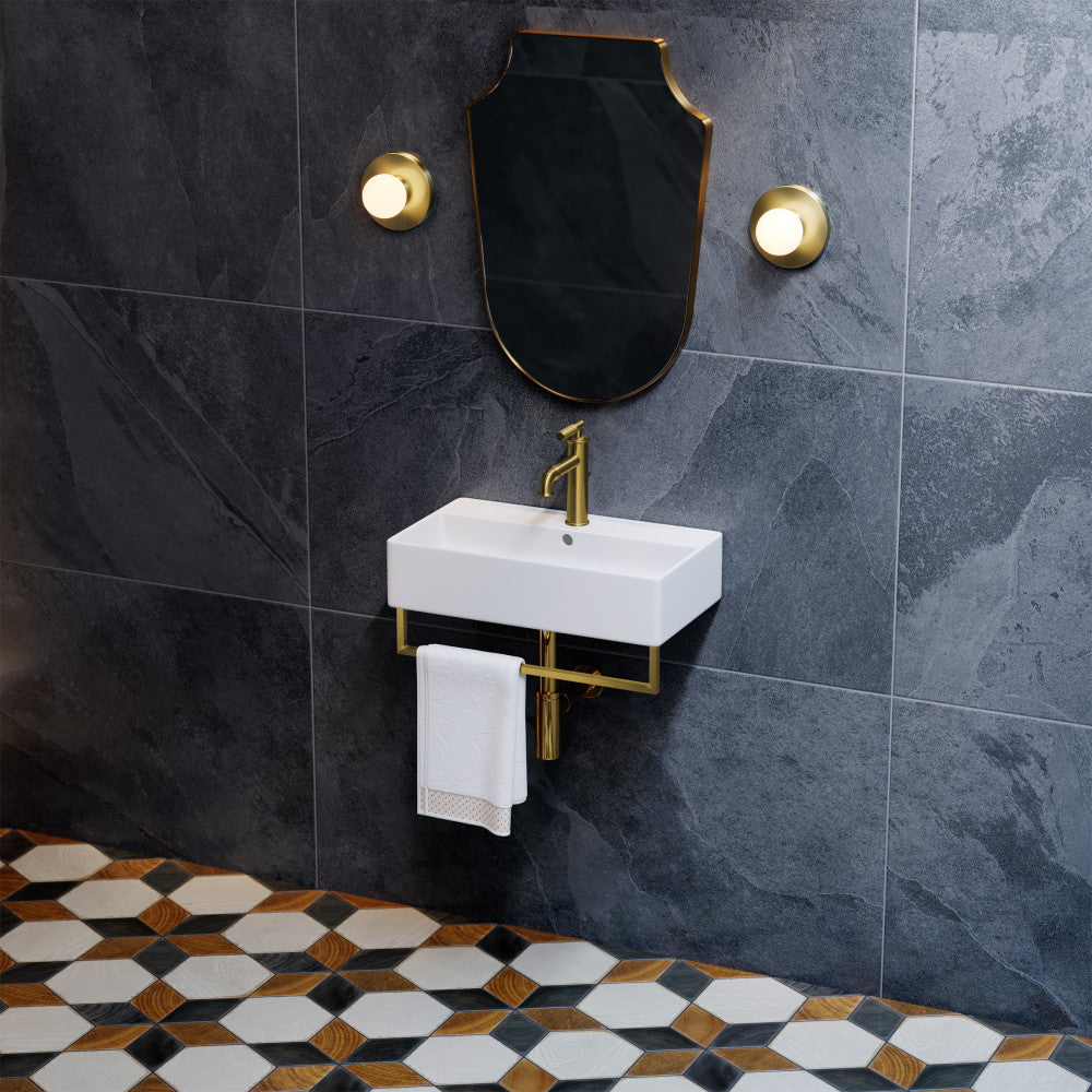 22" wall-mount bathroom sink with brushed gold towel bar and matching faucet on dark tile wall.