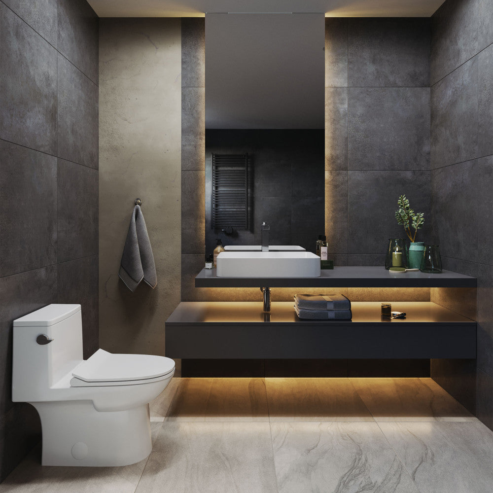 Elongated one-piece left side flush toilet with skirted trapway in modern bathroom setting.