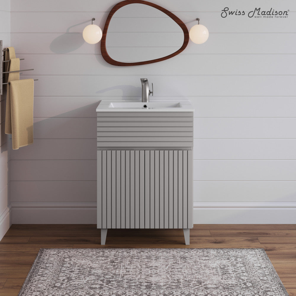 24-inch freestanding bathroom vanity in shell with single sink and vertically grooved cabinet doors.