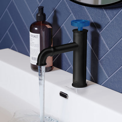 Single-handle bathroom faucet in matte black with blue wheel handle, mounted on white sink with running water.