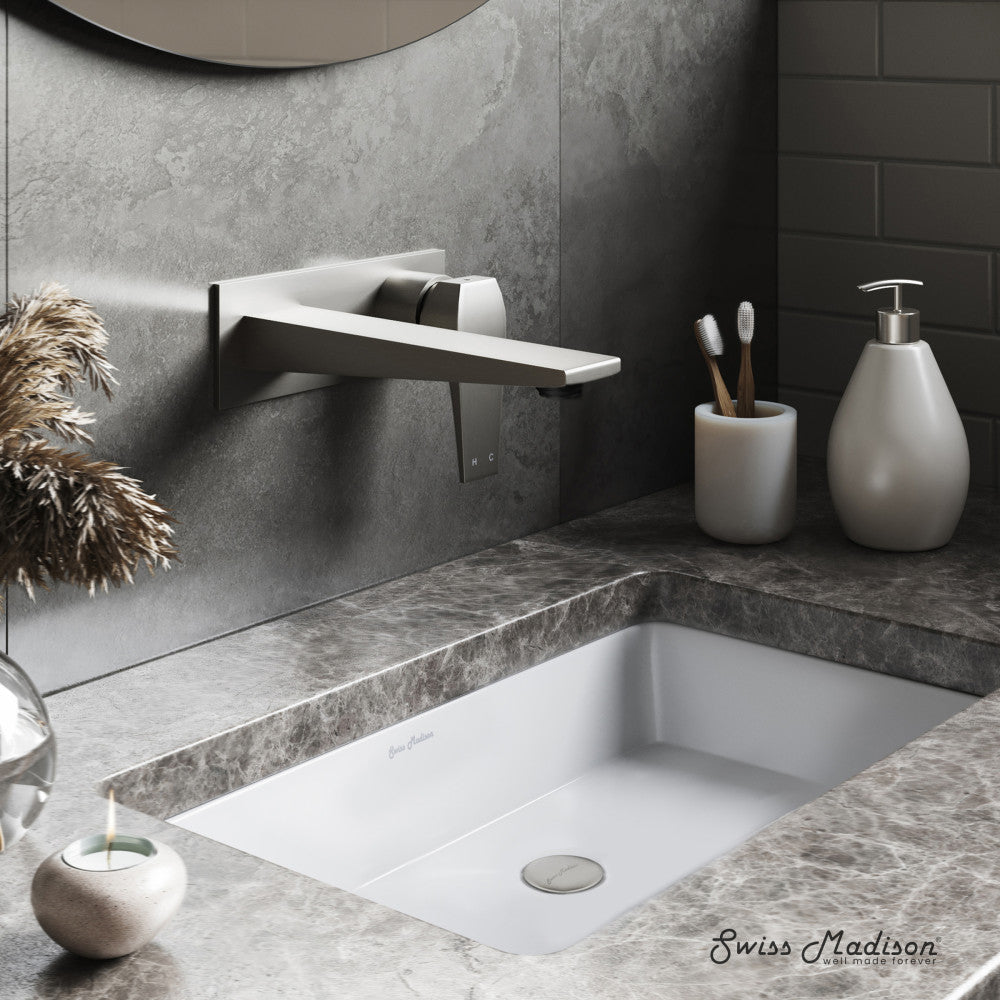 Wall-mount single-handle bathroom faucet in brushed nickel with sleek minimalist design above white sink.