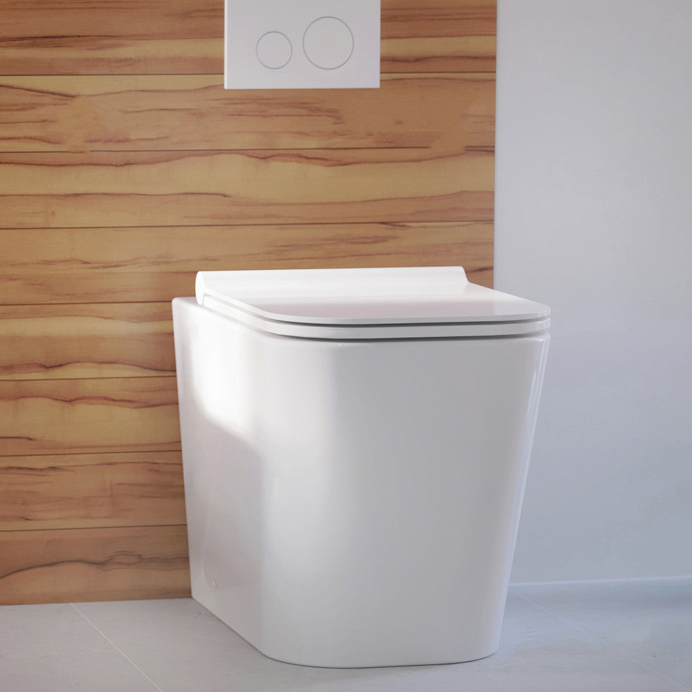 Square back-to-wall toilet bowl with soft-close seat in white porcelain.