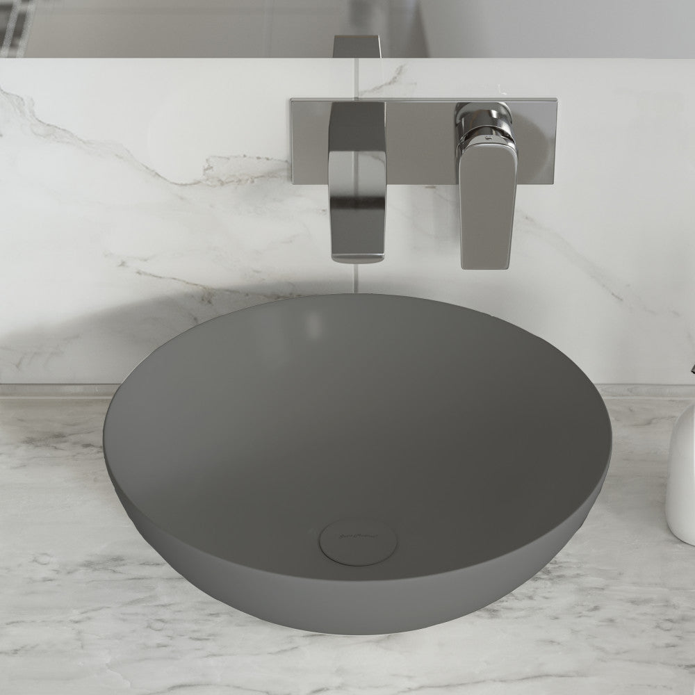 Matte gray round vessel ceramic sink with integrated drain hole and minimalist design.