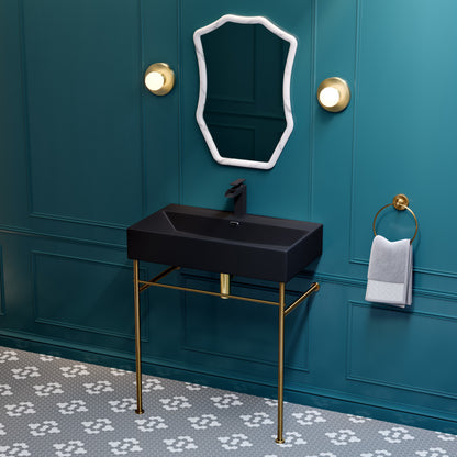 Matte black ceramic console sink with slim brushed gold legs and rectangular basin.