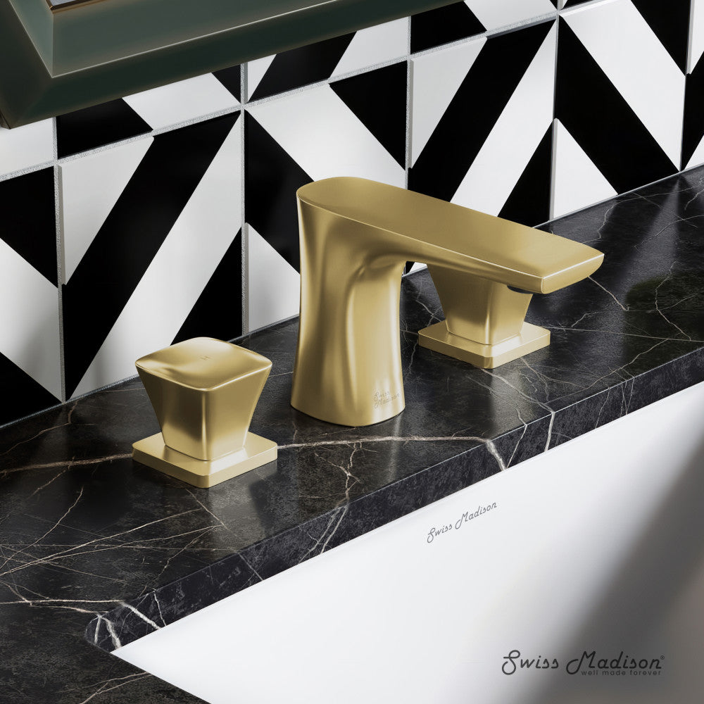 Widespread bathroom faucet in brushed gold with two square handles on black marble countertop.