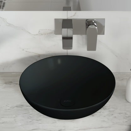 Round vessel sink in matte black ceramic with minimalist wall-mounted faucet and handle.