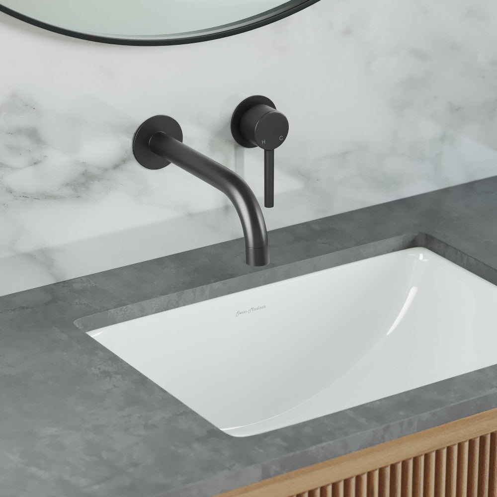Wall-mount bathroom faucet in matte black with single handle and curved spout over white rectangular sink.
