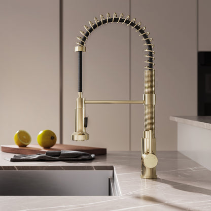 Single handle pull-down kitchen faucet in brushed gold with a flexible coil spring neck.