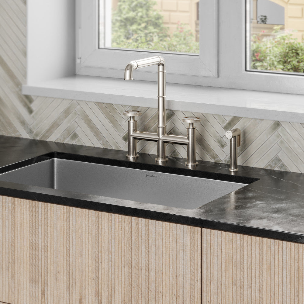 Widespread kitchen faucet in brushed nickel with high arc spout and side sprayer.