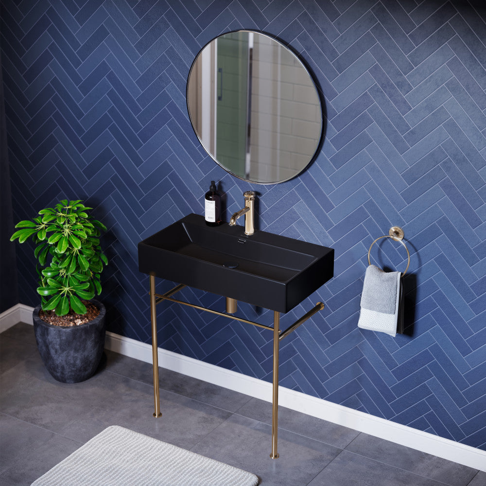 Matte black ceramic console sink with slim gold legs, rectangular basin, and single faucet hole.