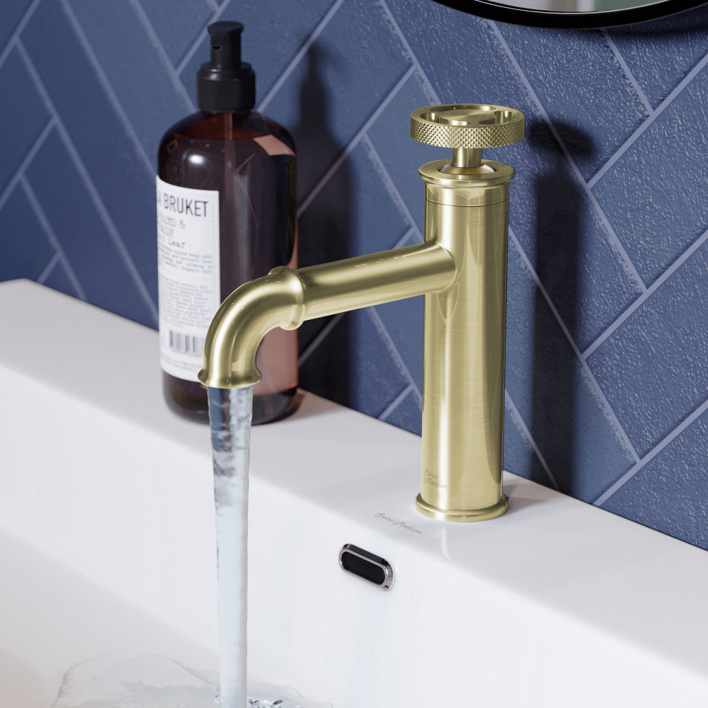 Single-handle bathroom faucet in brushed gold with wheel handle and cylindrical spout.
