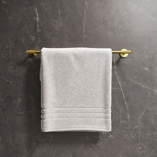24-inch towel bar in brushed gold with mounted white towel on dark marble wall.